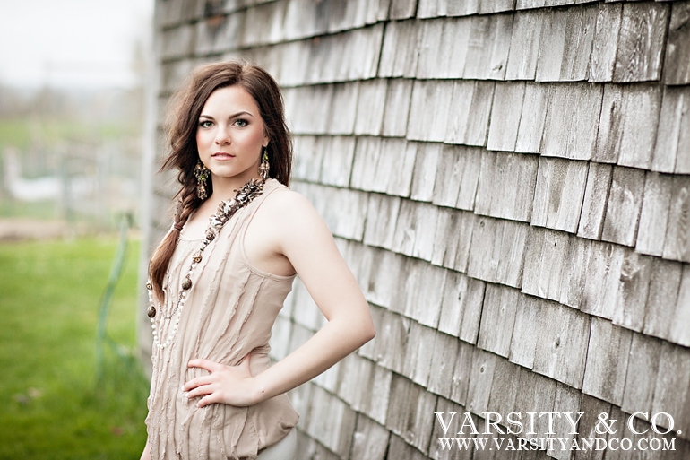 girl against a shingled barn senior picture