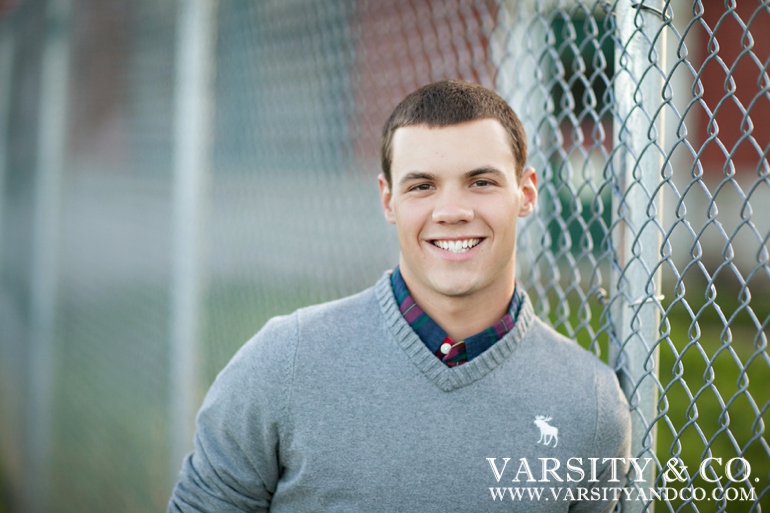 Guys senior pictures against a chain link fence