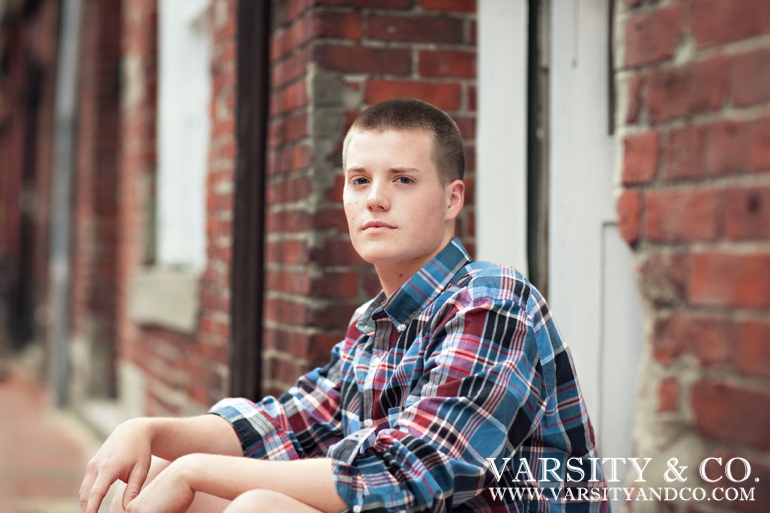 guy against a brick building senior picture