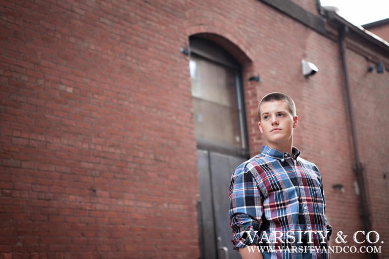 guy against a brick building senior picture