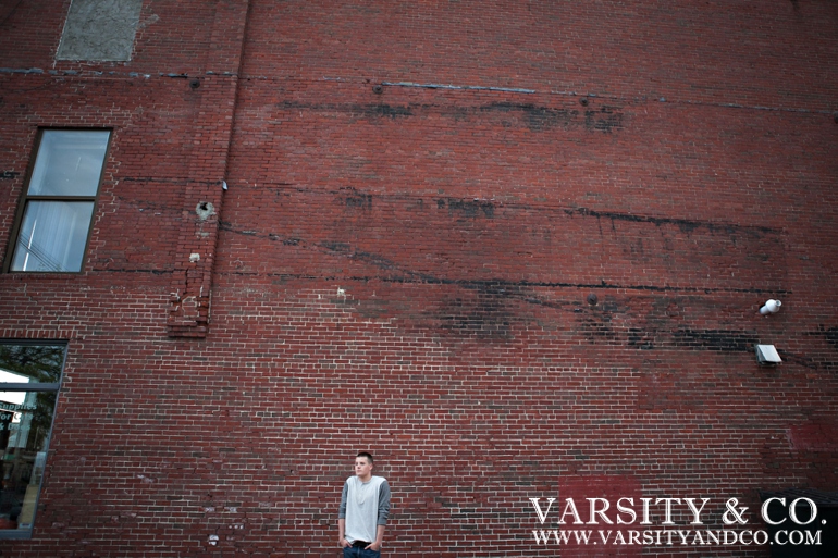 guy against a brick wall senior picture