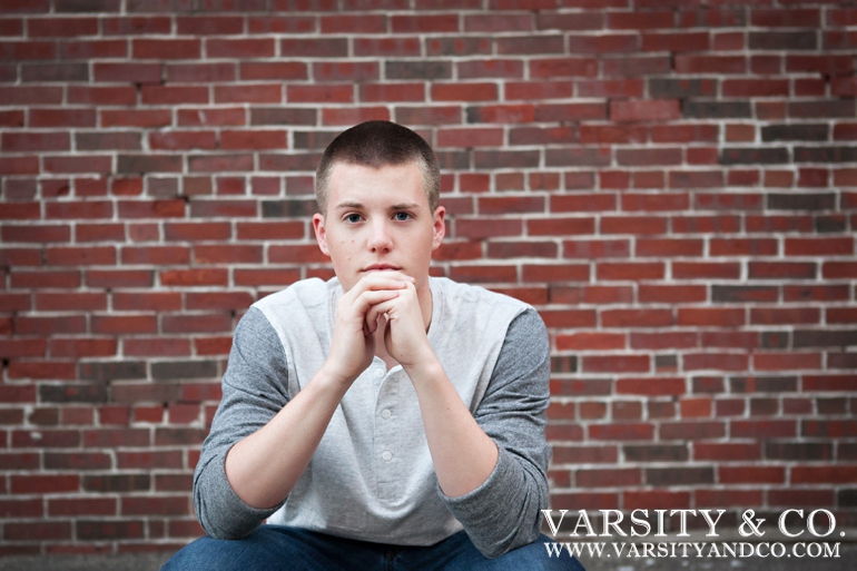 guy against a brick wall senior picture