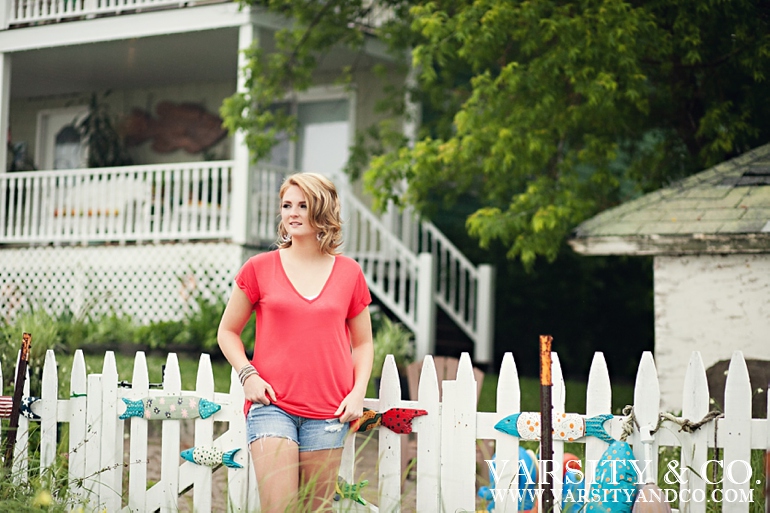 girl against a picket fence beach senior pictures