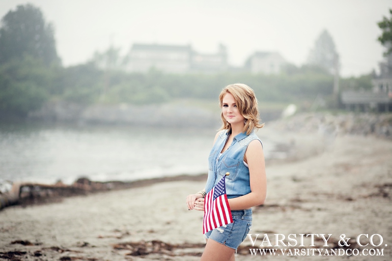 girl holding and american flag on the beach senior picture