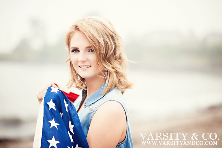 girl holding and american flag on the beach