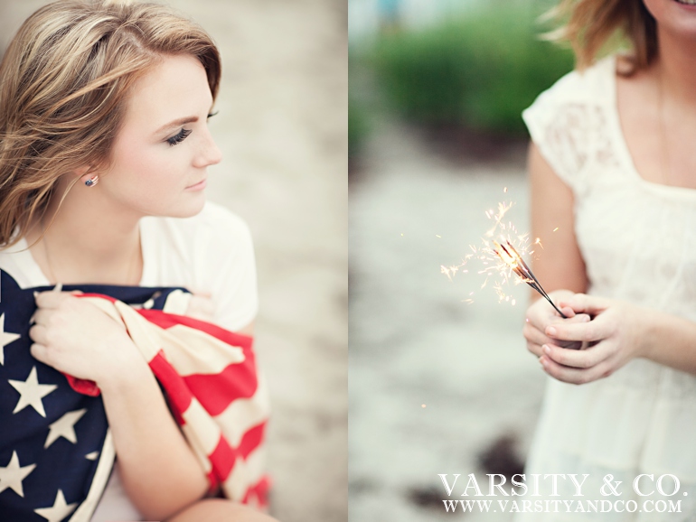 girl wrapped in american flag and holding a sparkler senior picture